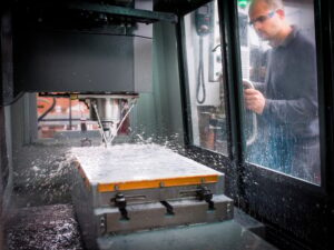 Knife factory worker monitoring machinery in workshop