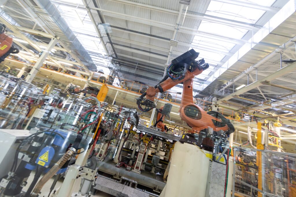 process of welding cars behind glass. Modern Assembly of cars at plant. automated build process of